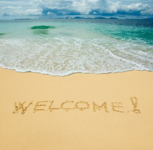 welcome written in a sandy tropical beach